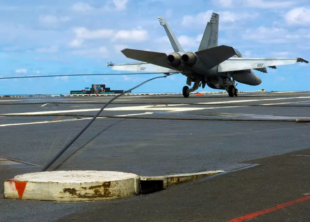 Naval aircraft engaging arresting wire on carrier deck, demonstrating early arresting technology